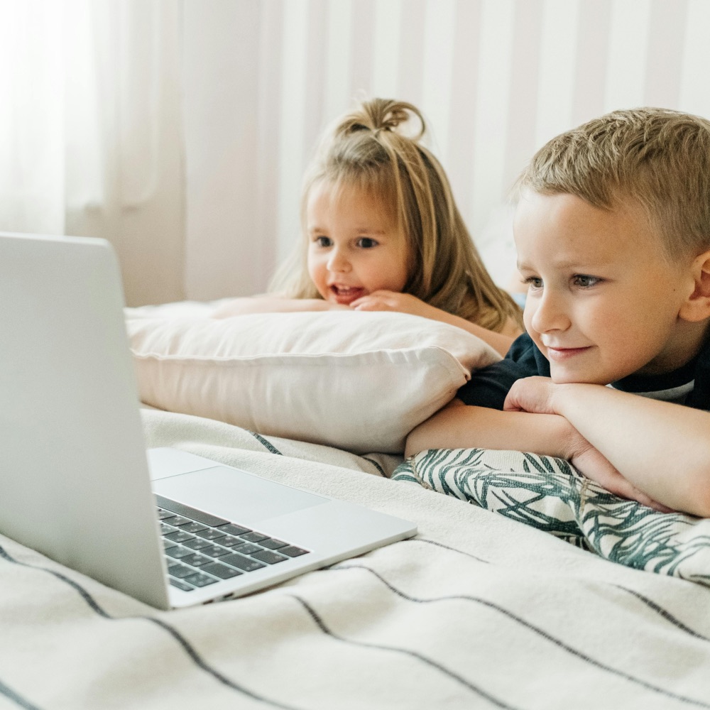 Toddler and her brother watching Diluu songs and stories on a laptop