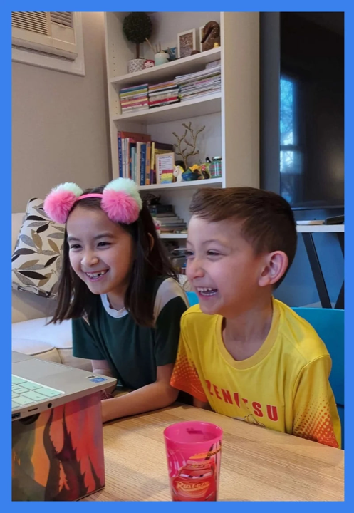 Deux enfants riant pendant leur cours en ligne Diluu