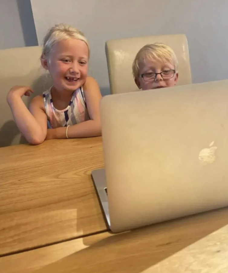 Deux enfants suivant leur cours de français Diluu sur un ordinateur